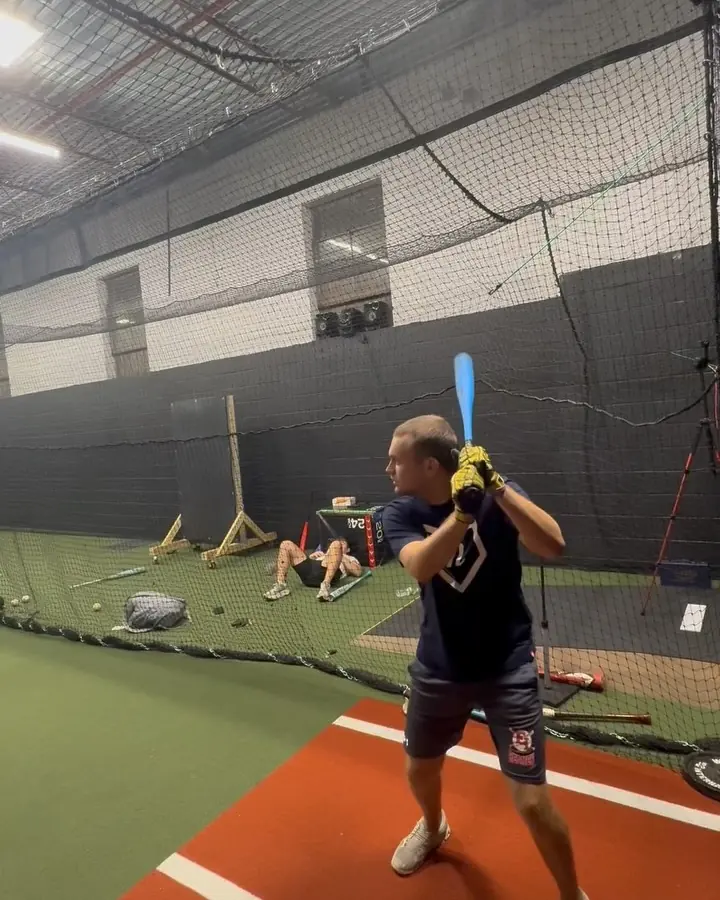 Wide view down the netted cage lane with turf mound and hitting station at the Lindenhurst facility